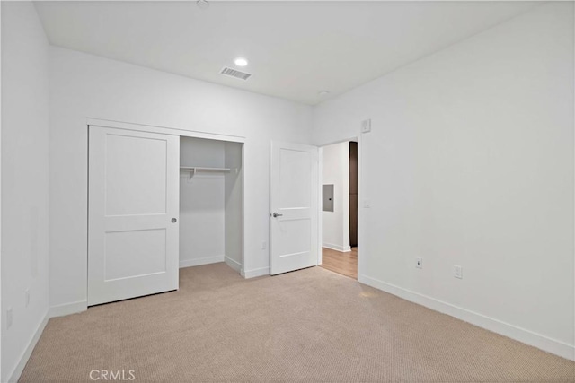 unfurnished bedroom featuring a closet and light carpet