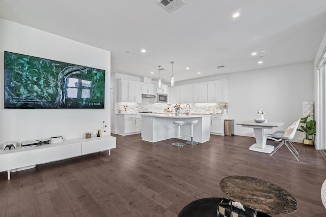 living room featuring sink and dark hardwood / wood-style floors