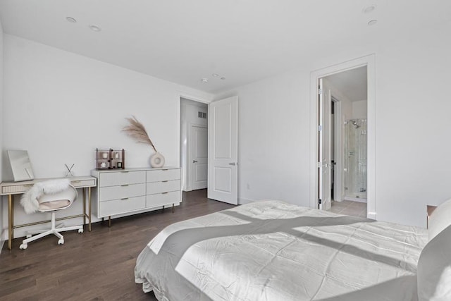 bedroom with dark wood-type flooring, ensuite bath, and a baseboard heating unit