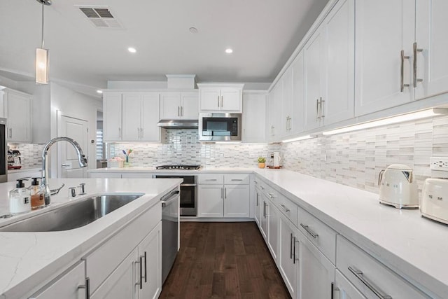 kitchen featuring decorative light fixtures, tasteful backsplash, white cabinetry, sink, and stainless steel appliances