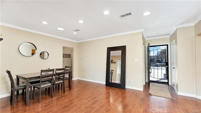 dining area with crown molding and dark wood-type flooring