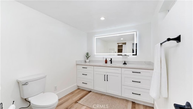 bathroom with vanity, toilet, and wood-type flooring