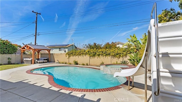 view of pool featuring a water slide, an in ground hot tub, a patio area, a gazebo, and an outdoor hangout area