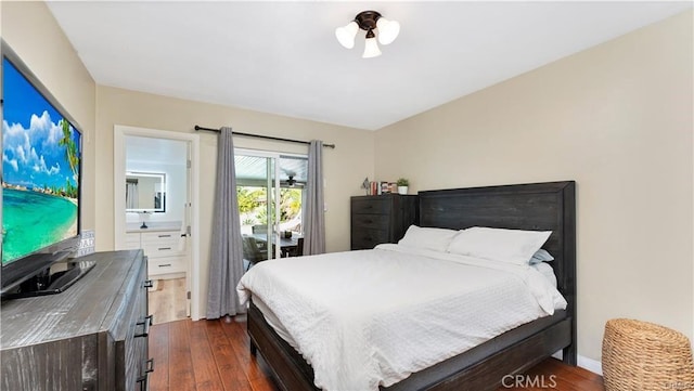 bedroom featuring dark hardwood / wood-style floors, ensuite bath, and access to outside