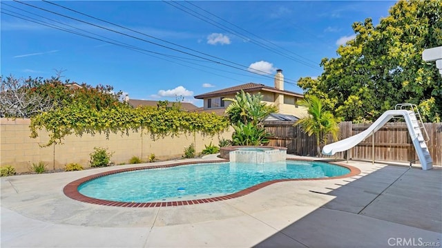 view of pool with an in ground hot tub, a patio area, and a water slide