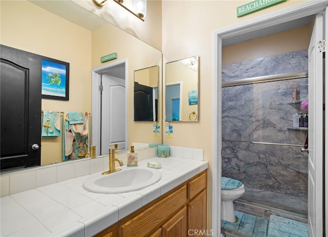 bathroom with vanity, toilet, and a tile shower