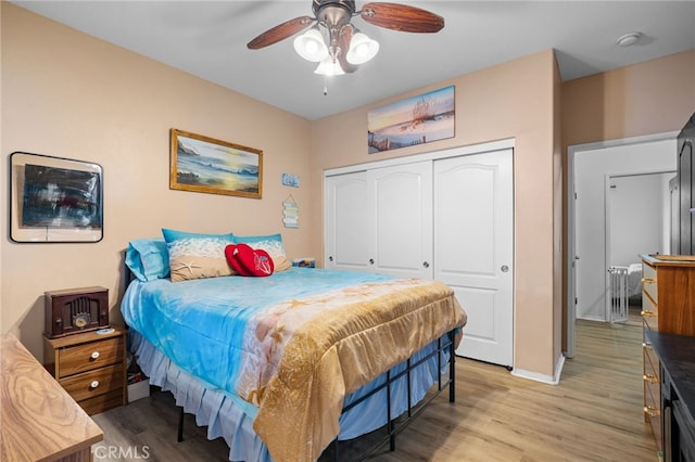 bedroom with light hardwood / wood-style flooring, a closet, and ceiling fan