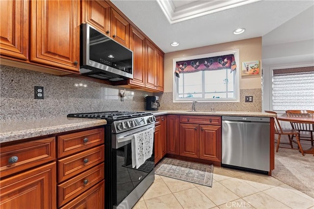 kitchen with tasteful backsplash, light tile patterned floors, sink, stainless steel appliances, and light stone counters