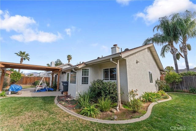 back of house with a patio area and a yard