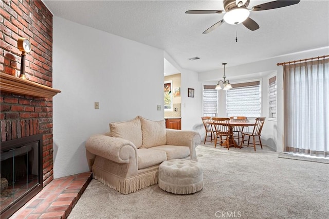 carpeted living room with a fireplace, a textured ceiling, and ceiling fan