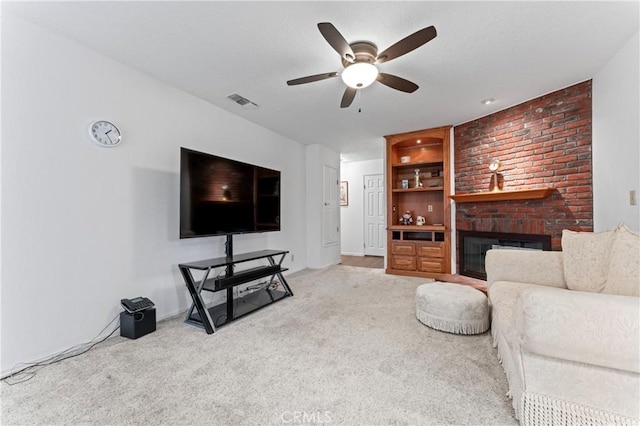 living room with ceiling fan, built in features, light colored carpet, and a brick fireplace