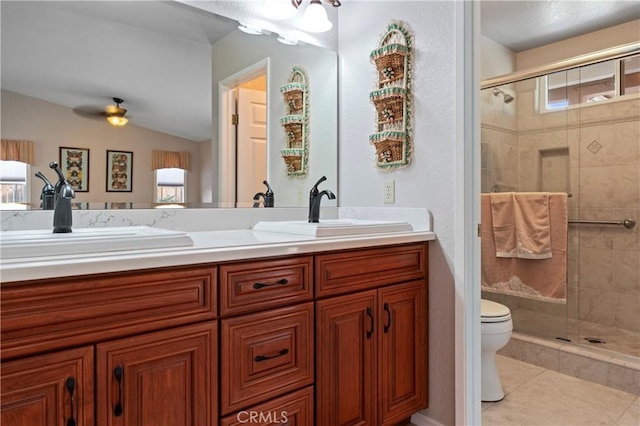 bathroom with tile patterned flooring, a shower with door, vanity, toilet, and ceiling fan