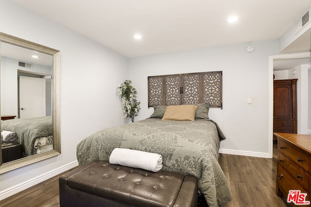 bedroom with dark hardwood / wood-style flooring