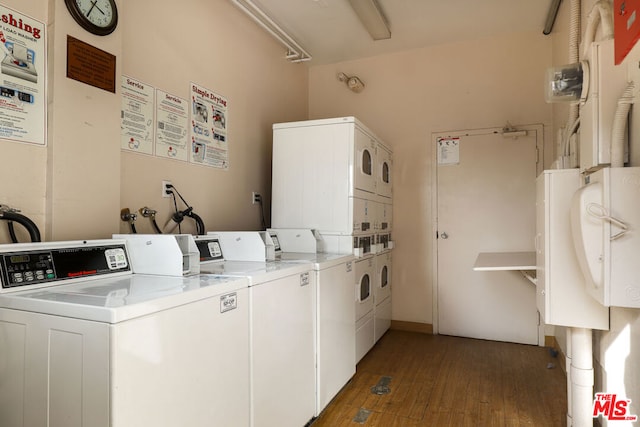 clothes washing area with stacked washer / dryer, washing machine and dryer, and dark hardwood / wood-style flooring