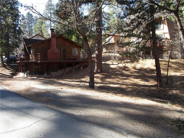 2440 Spruce Dr, Arrowbear, CA 92382 - view of side of home with a chimney and a wooden deck