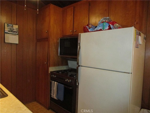 2440 Spruce Dr, Arrowbear, CA 92382 - kitchen with freestanding refrigerator, stove, light countertops, brown cabinets, and wood walls