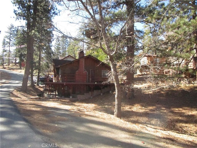 2440 Spruce Dr, Arrowbear, CA 92382 - view of side of home with a chimney and a wooden deck