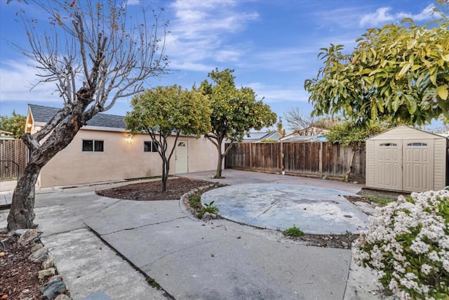 view of yard featuring a storage shed and a patio area