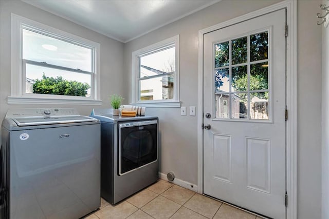 laundry area with light tile patterned floors and washer and clothes dryer