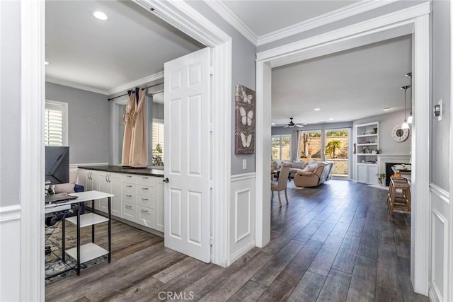 interior space featuring hardwood / wood-style floors, built in features, ornamental molding, and ceiling fan