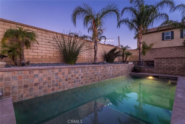 view of pool at dusk