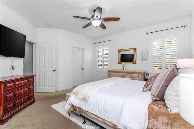 bedroom with multiple windows, light carpet, and ceiling fan