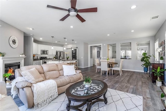 living room with ceiling fan and light hardwood / wood-style floors