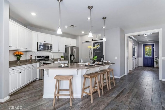 kitchen featuring white cabinetry, pendant lighting, a breakfast bar, and appliances with stainless steel finishes