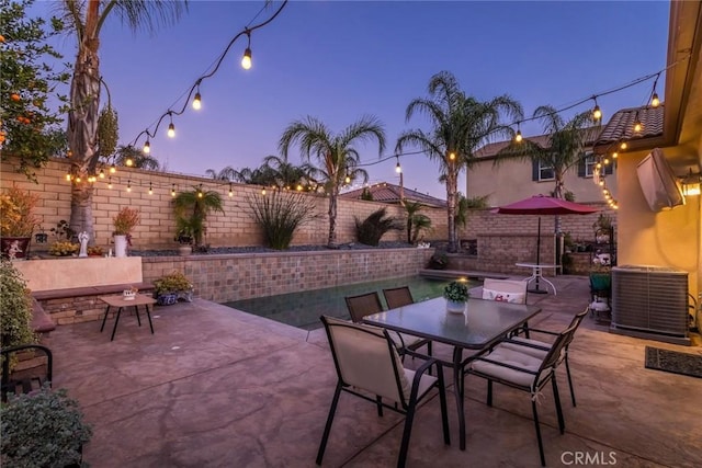 patio terrace at dusk featuring cooling unit