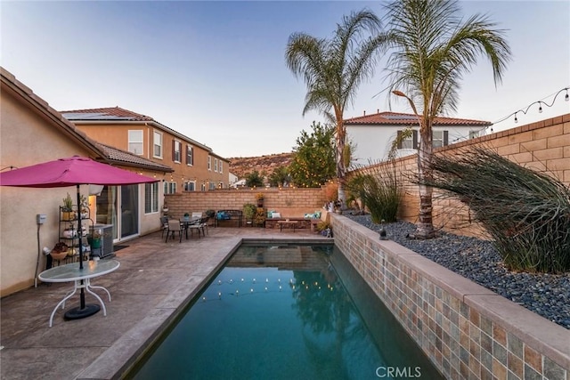 view of pool with a patio area and central air condition unit