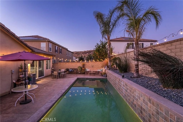 pool at dusk with a patio