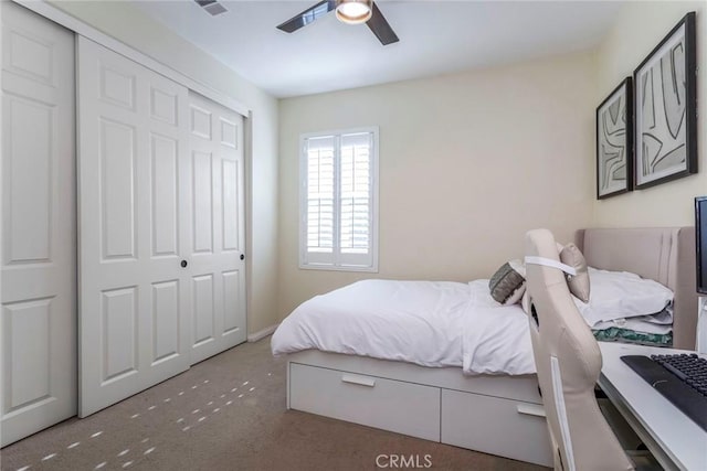 carpeted bedroom featuring ceiling fan and a closet