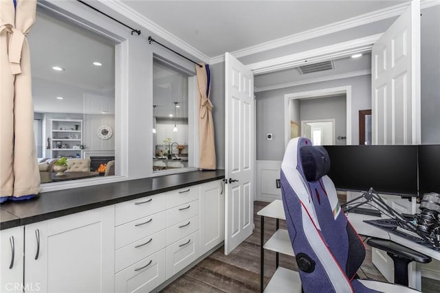 office space featuring sink, built in shelves, dark wood-type flooring, and ornamental molding