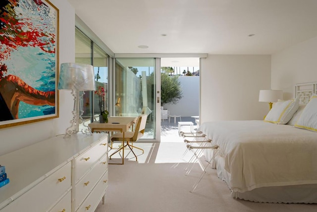 bedroom featuring floor to ceiling windows, access to exterior, and light carpet