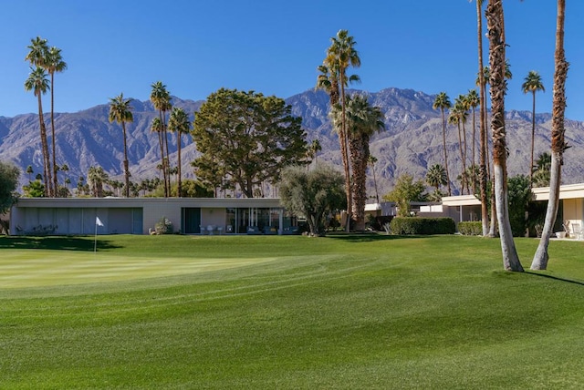 view of home's community with a mountain view and a lawn