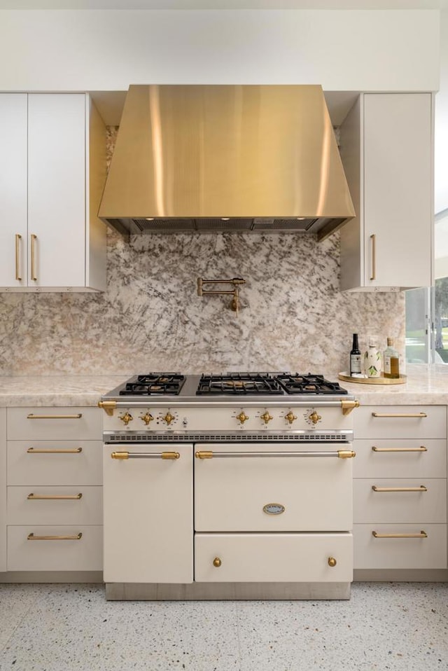 kitchen featuring tasteful backsplash, wall chimney range hood, and double oven range