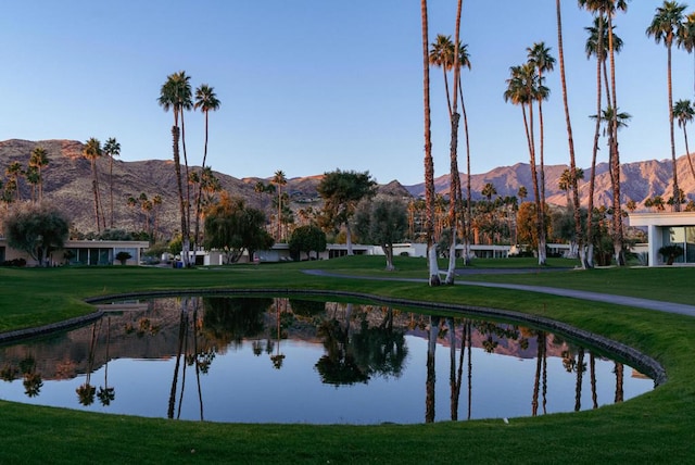 exterior space with a water and mountain view and a yard