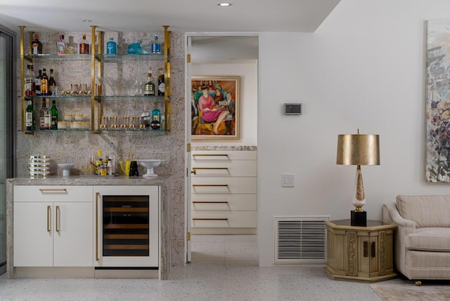 bar featuring wine cooler and white cabinetry