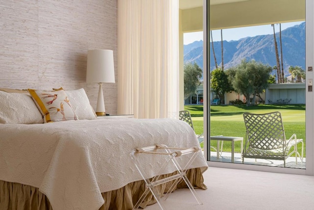 carpeted bedroom featuring a mountain view and access to outside