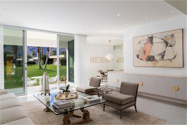 living room featuring floor to ceiling windows, a healthy amount of sunlight, and an inviting chandelier