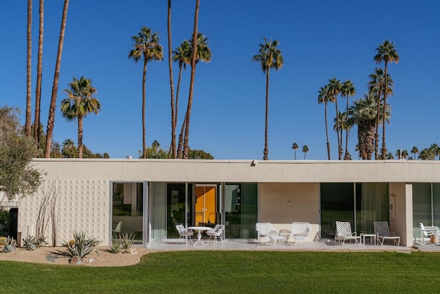 back of property featuring a lawn and a patio