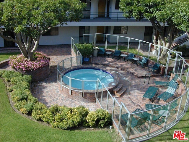 view of swimming pool featuring a patio and a jacuzzi