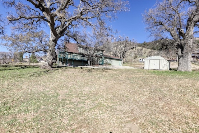 view of yard featuring a mountain view and a shed