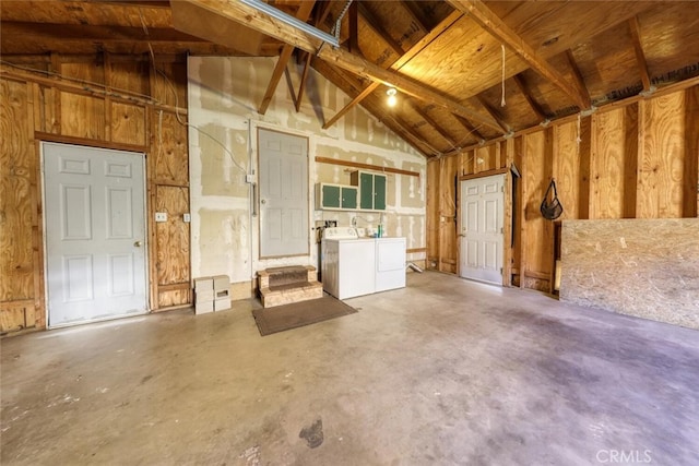 miscellaneous room with separate washer and dryer, concrete flooring, and vaulted ceiling