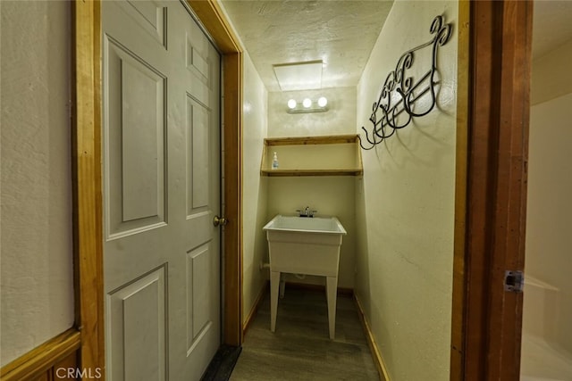 hall with wood-type flooring and a textured ceiling