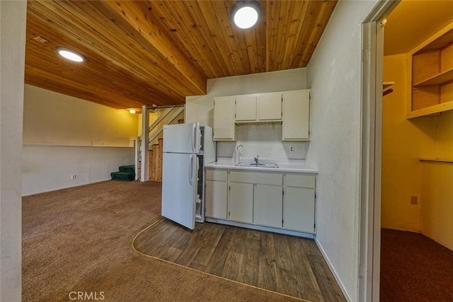 kitchen with sink, white refrigerator, white cabinets, wood ceiling, and dark colored carpet