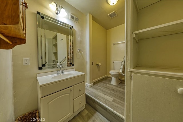 bathroom featuring vanity, toilet, and hardwood / wood-style floors