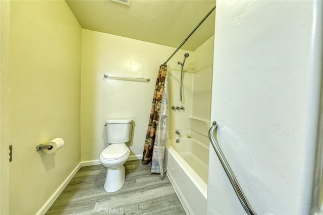 bathroom featuring hardwood / wood-style flooring, toilet, and shower / bathtub combination with curtain