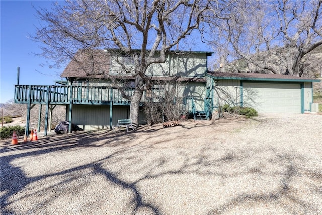 view of front facade with a garage, a wooden deck, and central AC