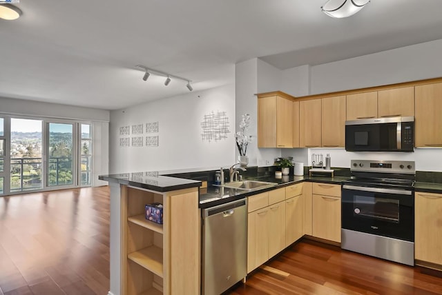 kitchen featuring stainless steel appliances, sink, light brown cabinetry, and kitchen peninsula